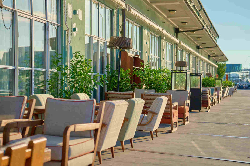 Stilvoll eingerichtete Hotelterrasse mit wetterfesten und langlebigen Möbeln aus Holz und Polyrattan.